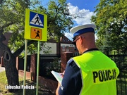 Policjant sprawdza oznakowanie przy szkołach i przedszkolach