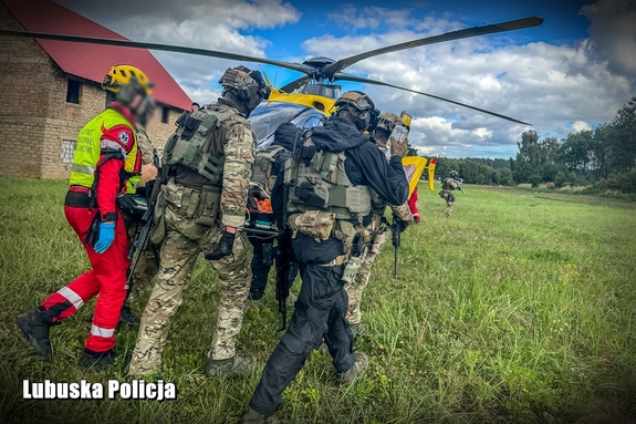 kontrterroryści i medycy transportują rannego do helikoptera