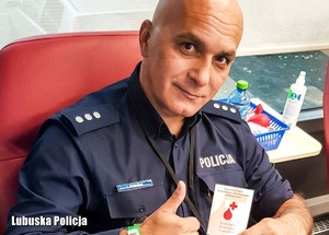 Policjant z legitymacją honorowego dawcy krwi