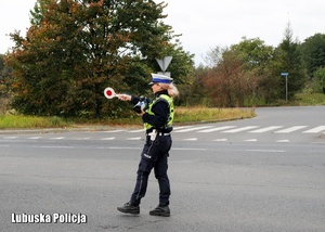 Policjantka drogówki zatrzymuje pojazd do kontroli drogowej.