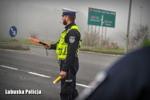 Policjant drogówki zatrzymuje pojazd do kontroli drogowej.