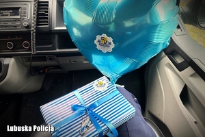 policjantka w radiowozie trzyma prezenty dla dziecka