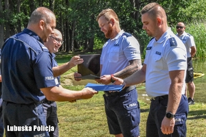 Policjant wręcza dyplom dla funkcjonariuszy