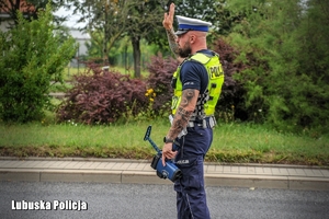 Policjant  ruchu drogowego daje znak do zatrzymania