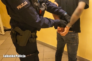 Policjant zakłada kajdanki podejrzanemu