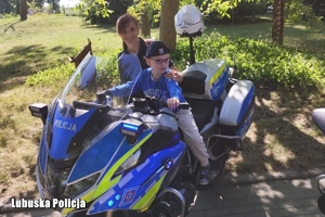 policjantka i jej synek siedzący na motocyklu