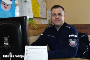 policjant siedzi przy biurku