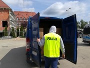 policjant otwiera bagażnik dostawczego samochodu