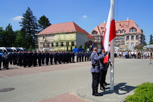 Policjanci przypinają flagę do masztu