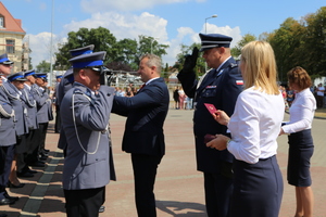 Policjant salutuje Komendantowi a Wojewoda przypina medal