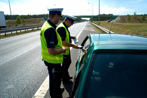 dwóch policjantów ruchu drogowego kontroluje dokumenty kierowcy