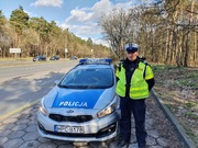 policjant ruchu drogowego stoi przy radiowozie