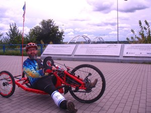 Pan Maciej na specjalnym wózku na tle mostu w Toruniu