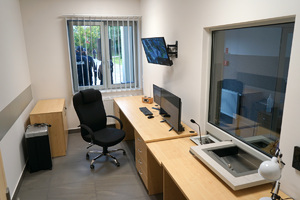 zdjęcie pokoju, w którym znajdują się meble, monitory oraz krzesło