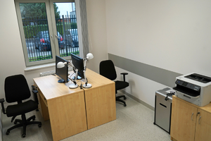 zdjęcie pokoju, w którym znajdują się meble, monitory, krzesła oraz drukarka