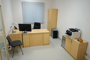 zdjęcie pokoju, w którym znajdują się meble, monitor, krzesło oraz drukarka