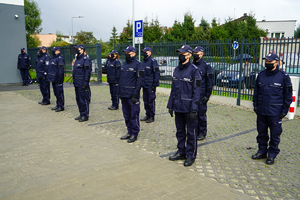 policjanci z posterunku stoją w szeregu przed budynkiem
