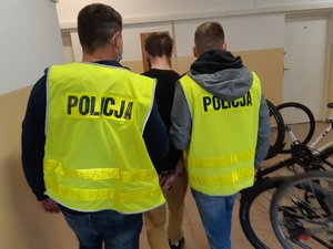 Policjanci prowadzą podejrzanego o kradzieże rowerów