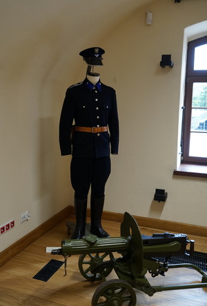 Mundur policjanta oraz armatka na ekspozycji w sali muzeum.