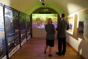 Policjantka i policjant oglądają wystawę oraz wyświetlany film w jednej z sal muzeum.