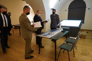 Zaproszeni goście zapoznają się z książką „Martyrologia policjantów Policji Państwowej województwa pomorskiego”.