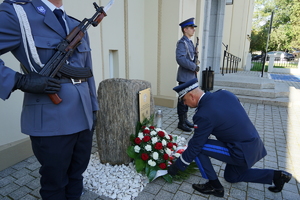 Komendant klęka przed Kamieniem Pamięci ku czci poległych policjantów
