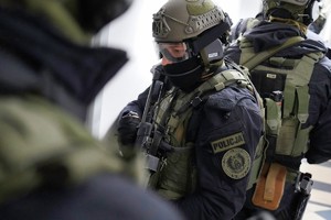 Dwóch uzbrojonych policjantów stoi plecami do siebie