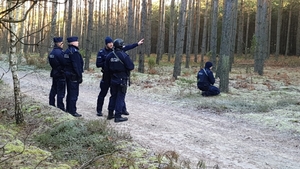 policjanci stoją na leśnej drodze