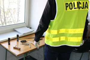 policjant zabezpiecza niebezpieczne narzędzia znalezione u zatrzymanego