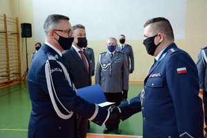 sala gimnastyczna OPP w Łodzi. uroczystość ślubowania policjantów. komendant wręcza akt mianowania na wyższy stopień