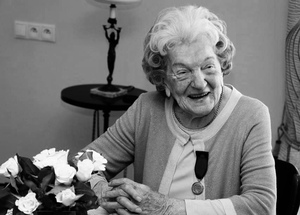 Czarno-białe zdjęcie uśmiechniętej starszej kobiety.
