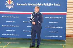 Sala gimnastyczna OPP w Łodzi, uroczystość ślubowania policjantów, przemówienie komendanta.