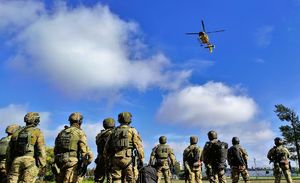 Policjanci patrzą na lecący helikopter