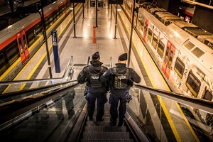 policjanci zabezpieczają szczyt OBWE, policjanci zjeżdżają schodami ruchomymi na dworcu kolejowym