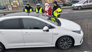 Policjantka z Mikołajem przy samochodzie