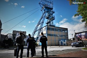 umundurowani policjanci obserwują budynki kopalni