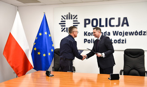 Komendant Wojewódzki Policji w Łodzi oraz Prezydent Skierniewic za stołem podają sobie rękę.
