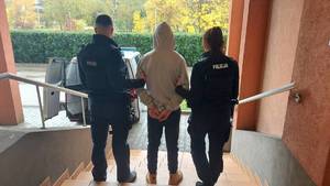 Policjanci prowadzą zatrzymanego.