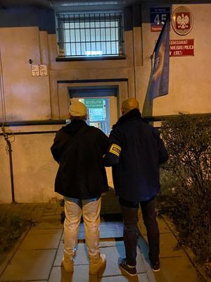 Policjant w cywilu z zatrzymanym mężczyzną.