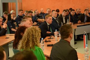 uczestnicy konferencji przy stołach podczas wystąpienia