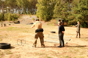 strzelnica rekreacyjna, instruktorzy pokazują gościom jak obsługiwać karabinek.