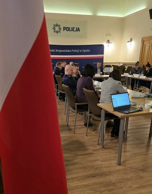 Uczestnicy szkolenia siedzą przy stołach ustawionych w podkowę.