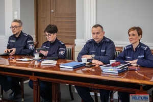 Czworo członków zespołu siedzi za stołem podczas posiedzenia.
