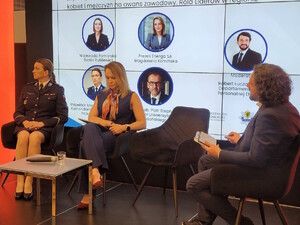 Troje panelistów, w tle slajd z prezentacji.