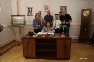 Zdjęcie przedstawia uczestników projektu pozujących wspólnie przy księdze pamiątkowej znajdującej się w Muzeum Polskiej Policji.