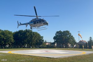 Zdjęcie przedstawia schodzący do lądowania helikopter typu Bell.