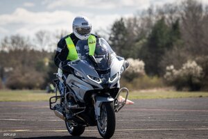 Zdjęcie przedstawia policjanta na motocyklu w trakcie szkolenia doskonalącego technikę jazdy.