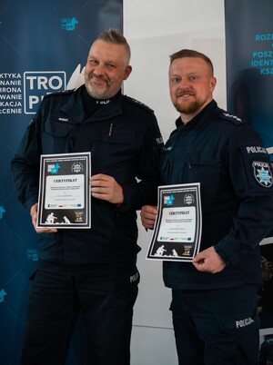 Dwaj policjanci prezentują swoje certyfikaty.