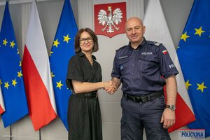 Zdjęcie przedstawia Zastępcę Komendanta Głównego Policji Rafała Kochańczyka oraz Dyrektor CUPT panią Joannę Lech ściskających sobie dłonie w geście odzwierciedlającym podpisanie umowy.