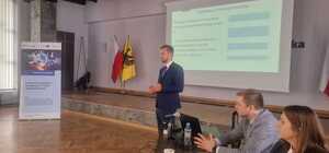 Zdjęcie przedstawia jednego z trenerów prowadzących szkolenie dla operatorów systemu Europolu podczas panelu szkoleniowego.